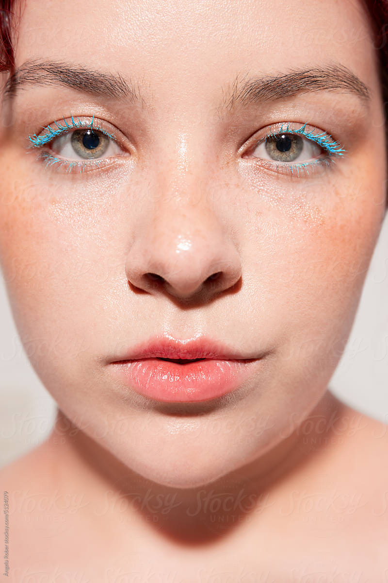 Young woman with green eyes and blue eyelashes