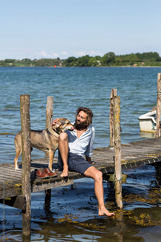 Young man and his dog on a jetty