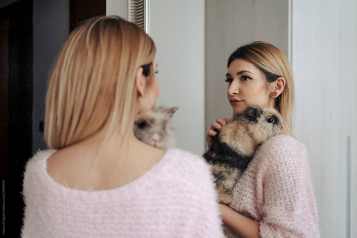 Woman in front of a mirror with her cute rabbit