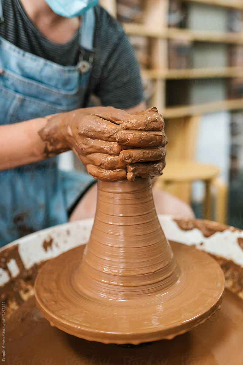 Crop potter creating clay vessel