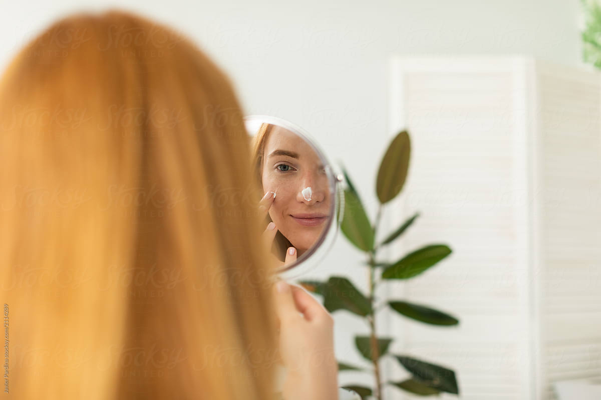Redhead Woman Looking At Her Reflection In Mirror By Stocksy Contributor Javier Pardina 
