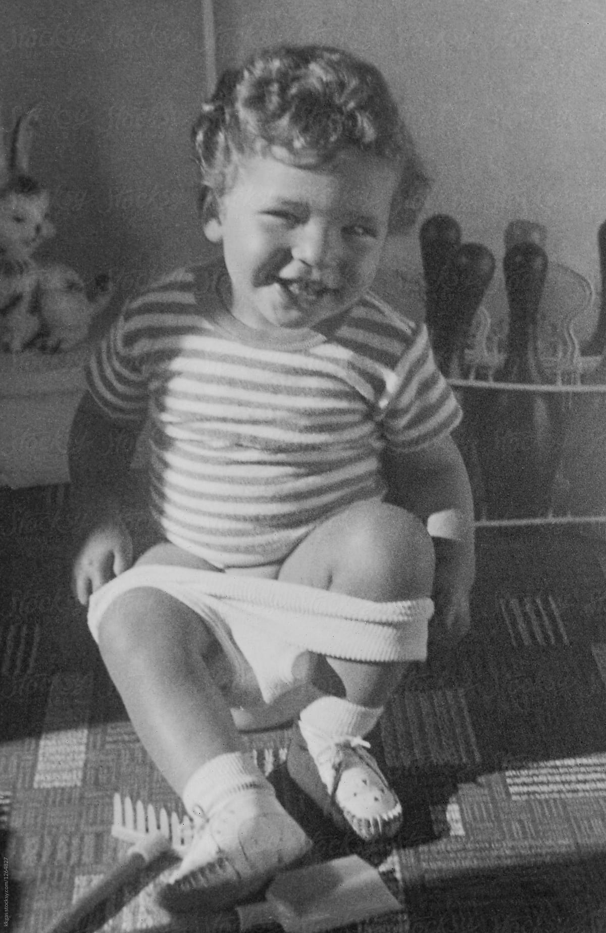 Scanned vintage photo of small child sitting on a potty