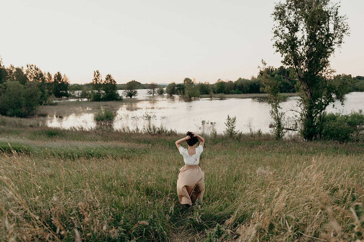 Young woman walking towards a lake