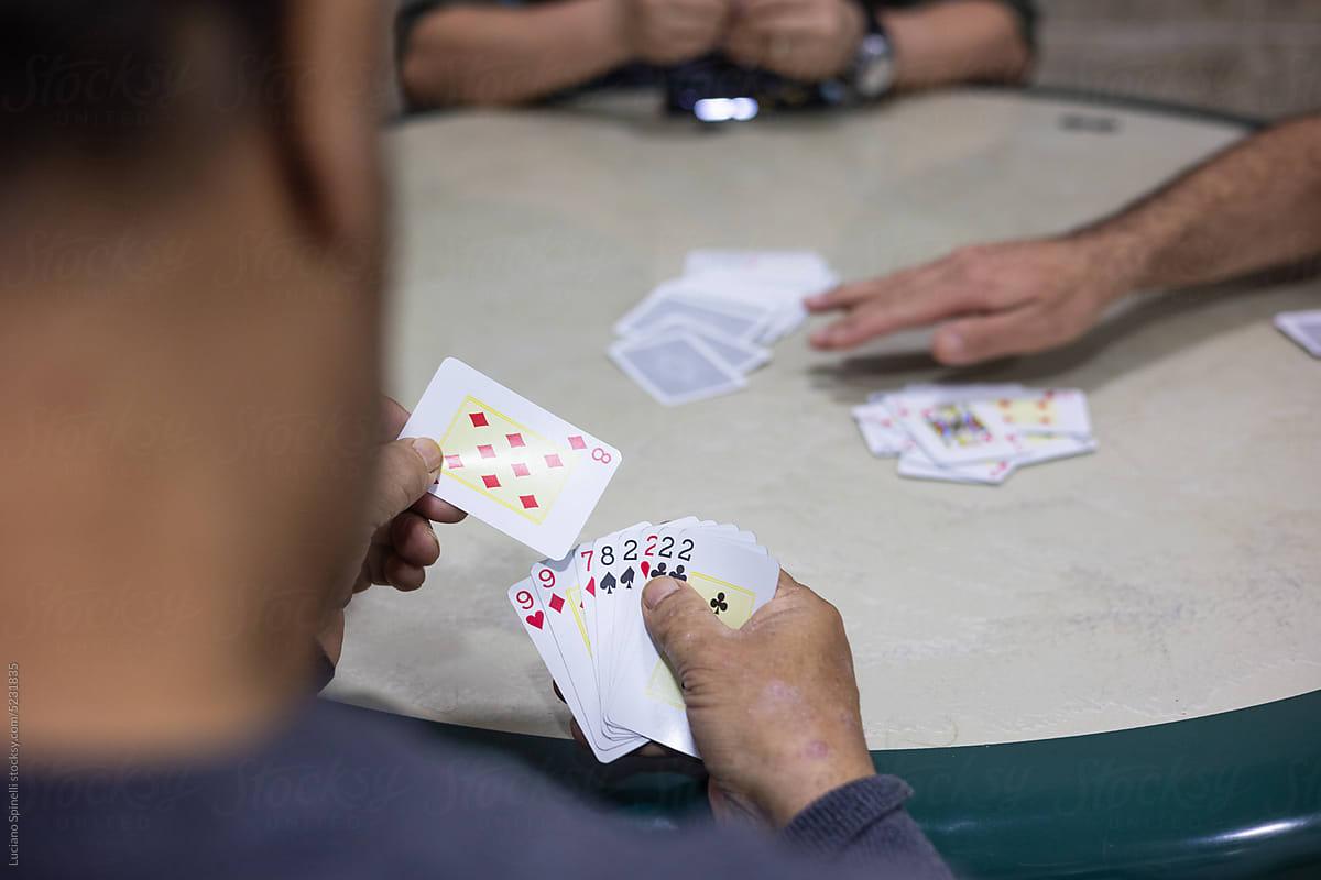 Anonymous men in Brazil playing cards in the bar and betting money