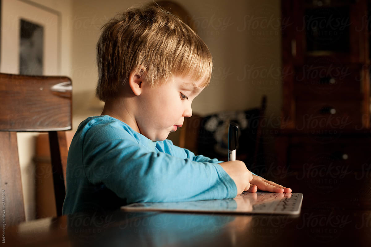 Little boy writing on a dry erase board