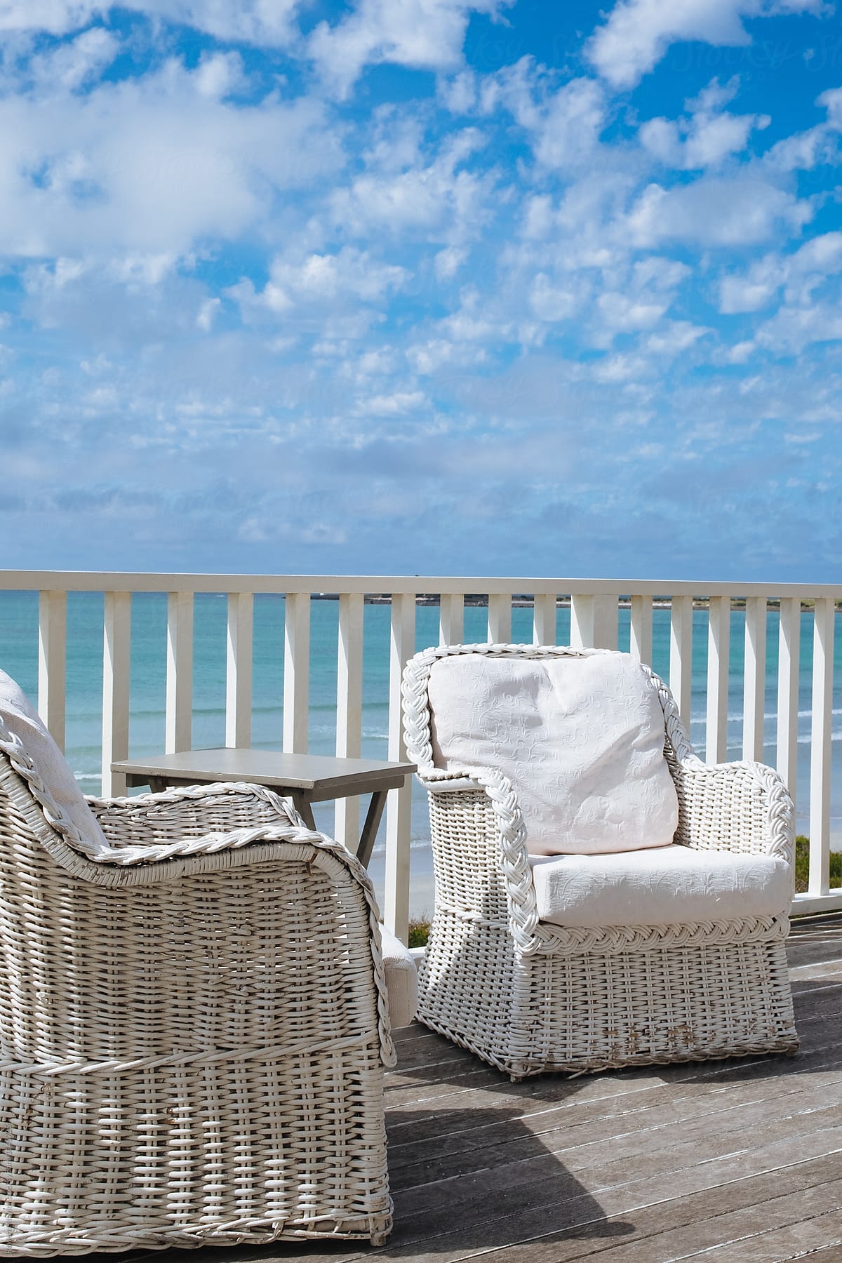 White rattan chairs on beachfront property