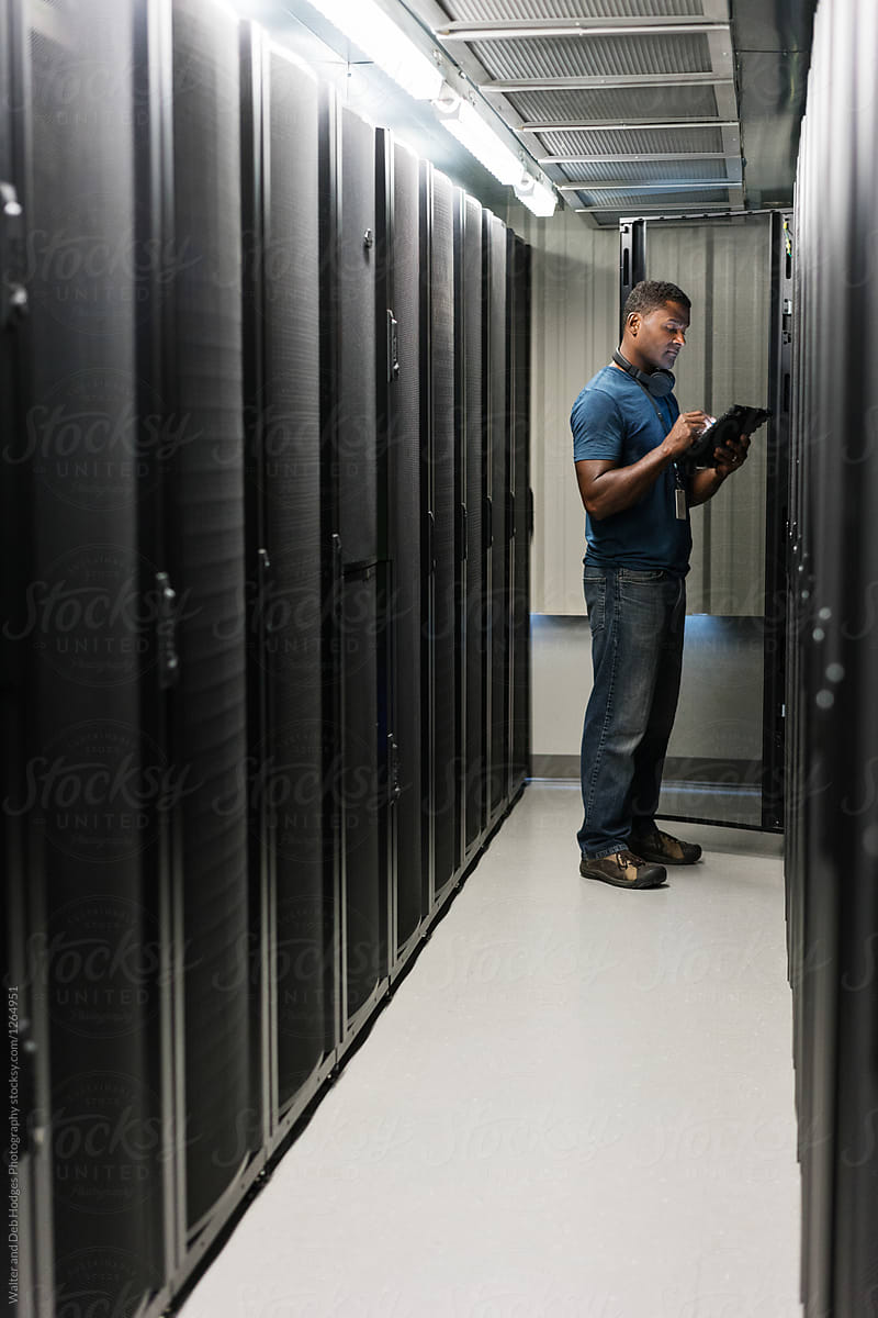 Vertical shot of server room technician looking at digital table