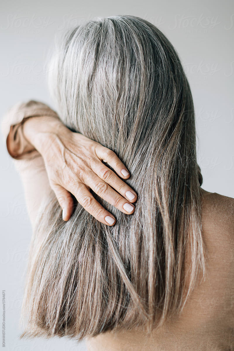 Back view of a senior woman with grey long hair.