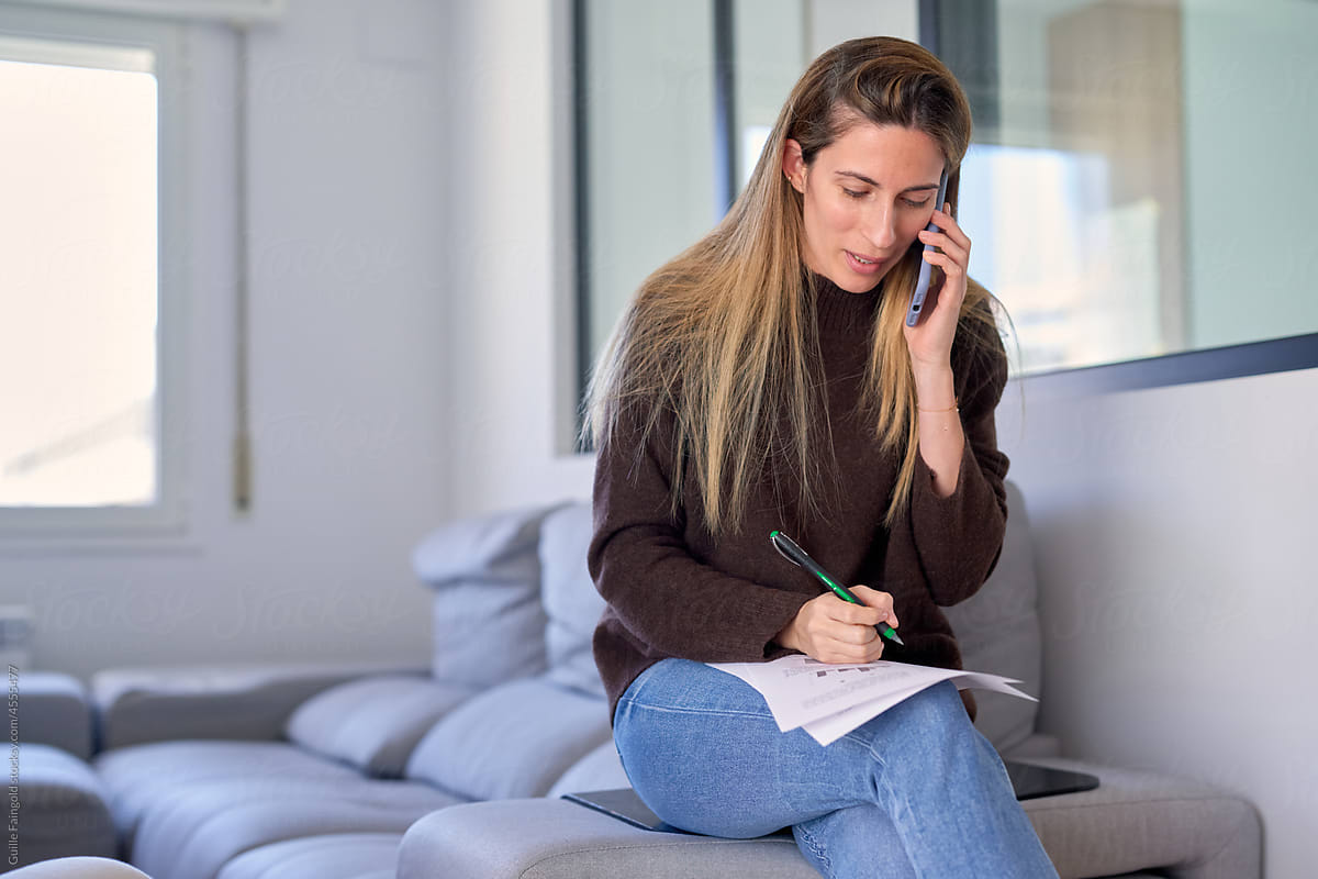Businesswoman making notes during phone call