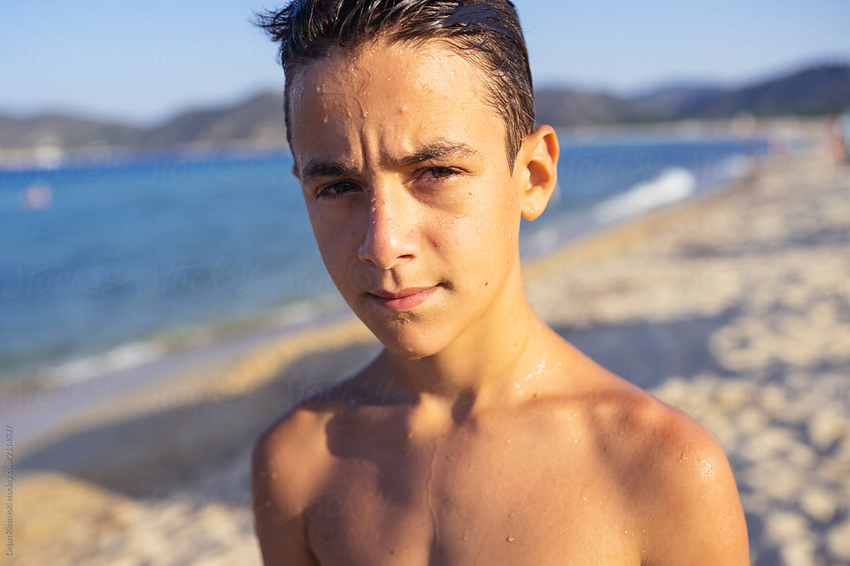 Handsome young boy looking at camera on the beach by Dejan Ristovski ...