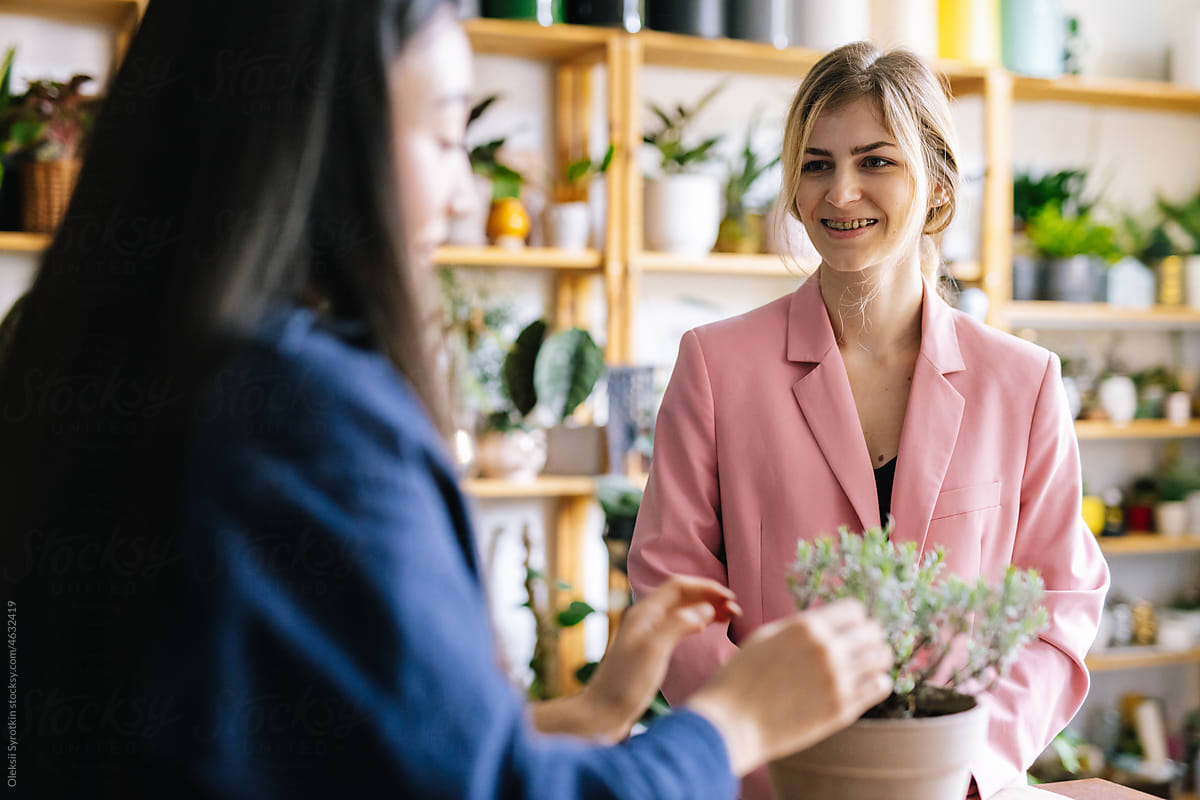 Saleswoman consulting female visitor in floral shop