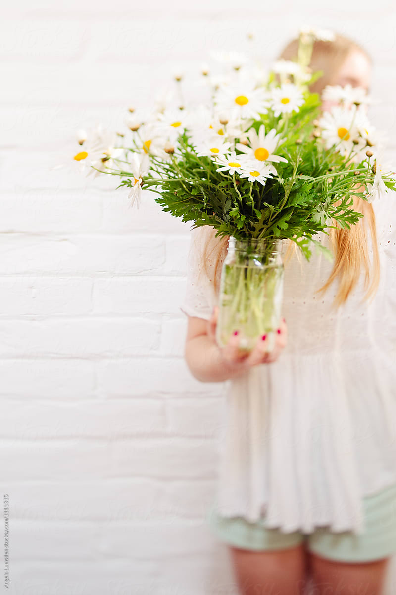 Girl holding a bunch of daisies in spring