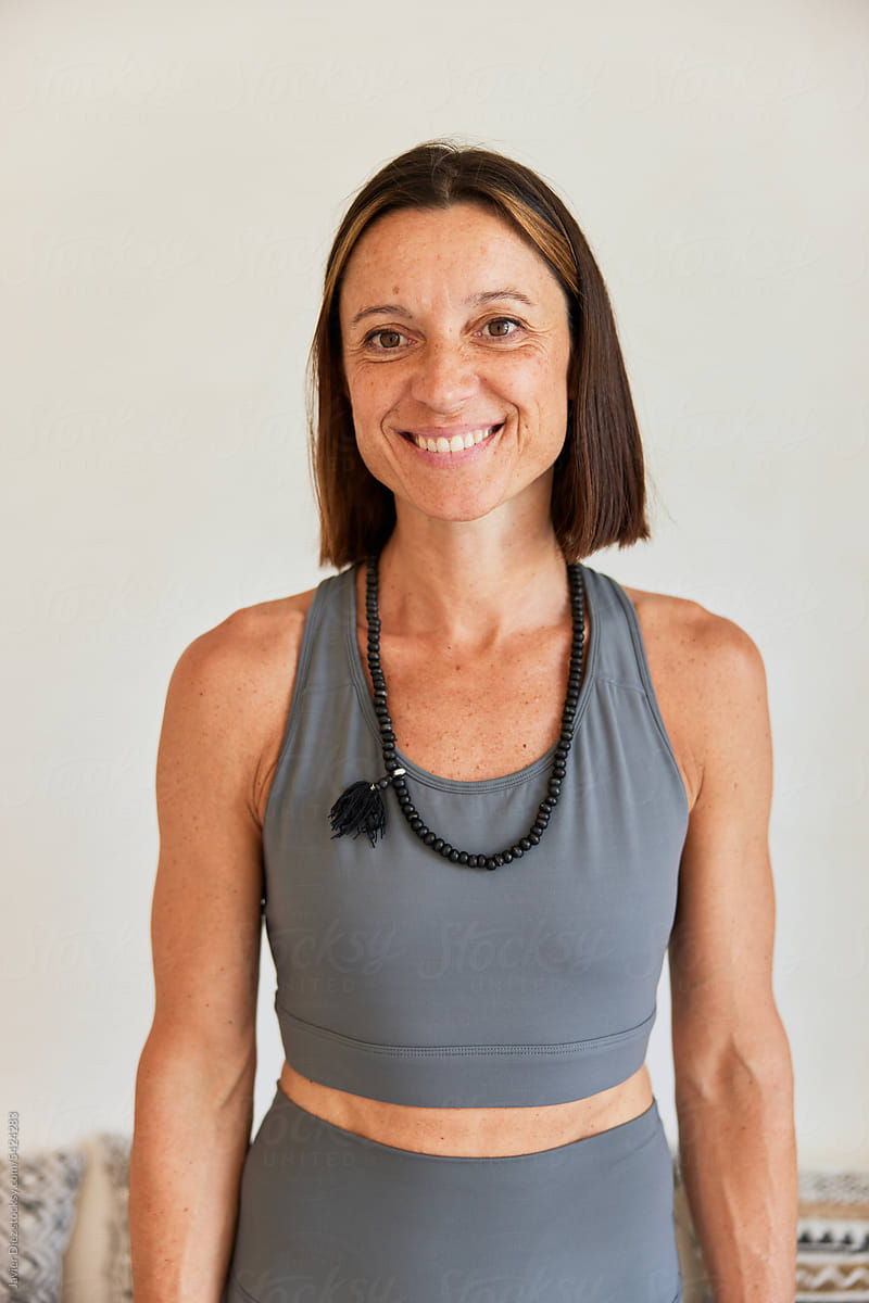 Positive lady in activewear on white backdrop