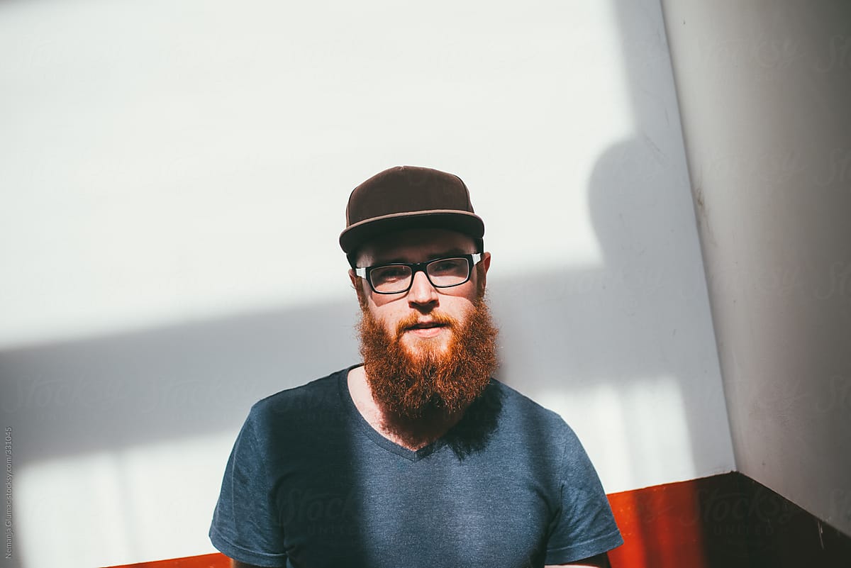Portrait of Young Alternative Man With Red Beard and Cap