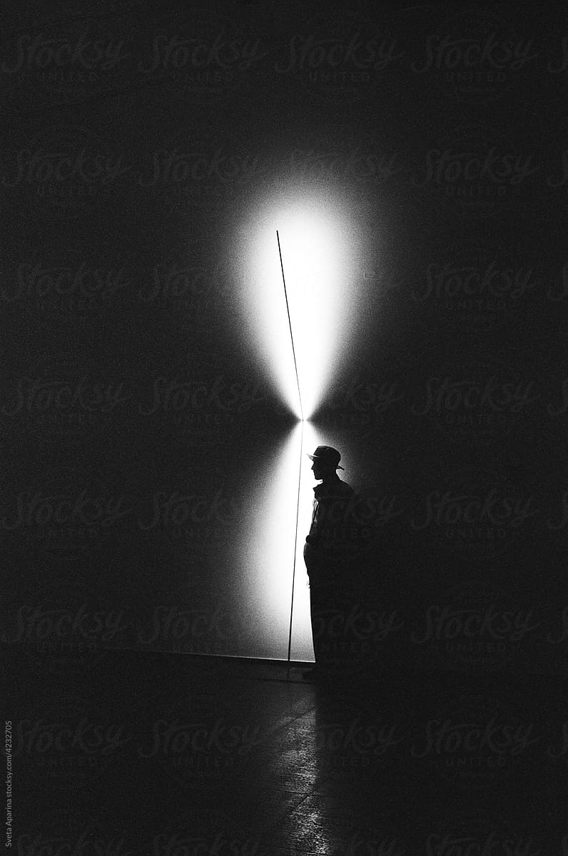 the silhouette of a guy standing against the background of spots of light