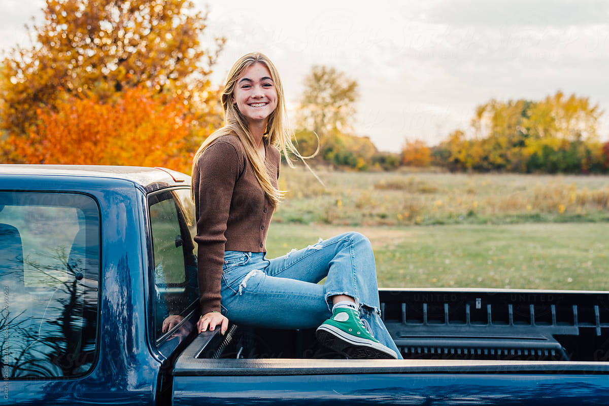 Teenage girl sitting on truck