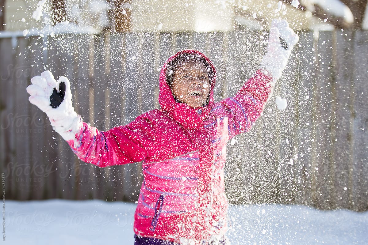 Tween girl throwing snow happily into the air