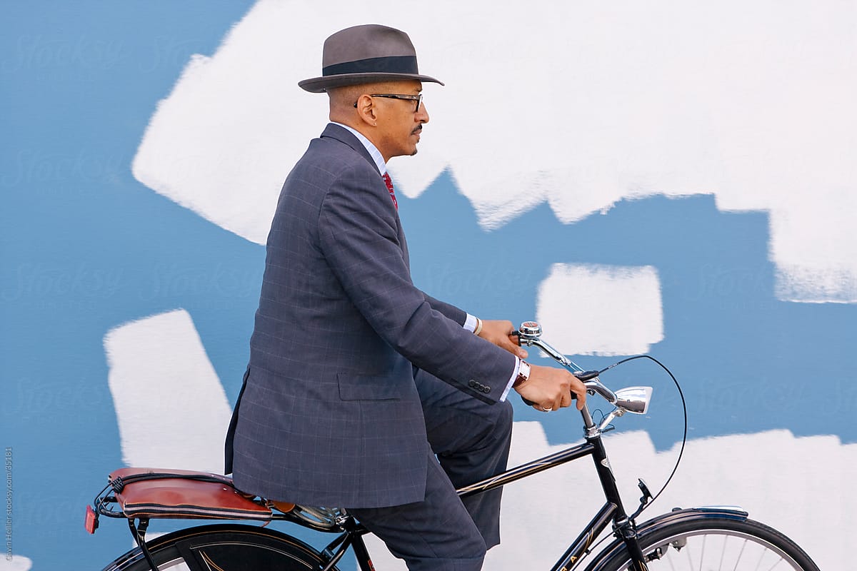 Bermuda, Atlantic Ocean, Hamilton, Businessman riding his bicycle in front of a colourfully painted wall