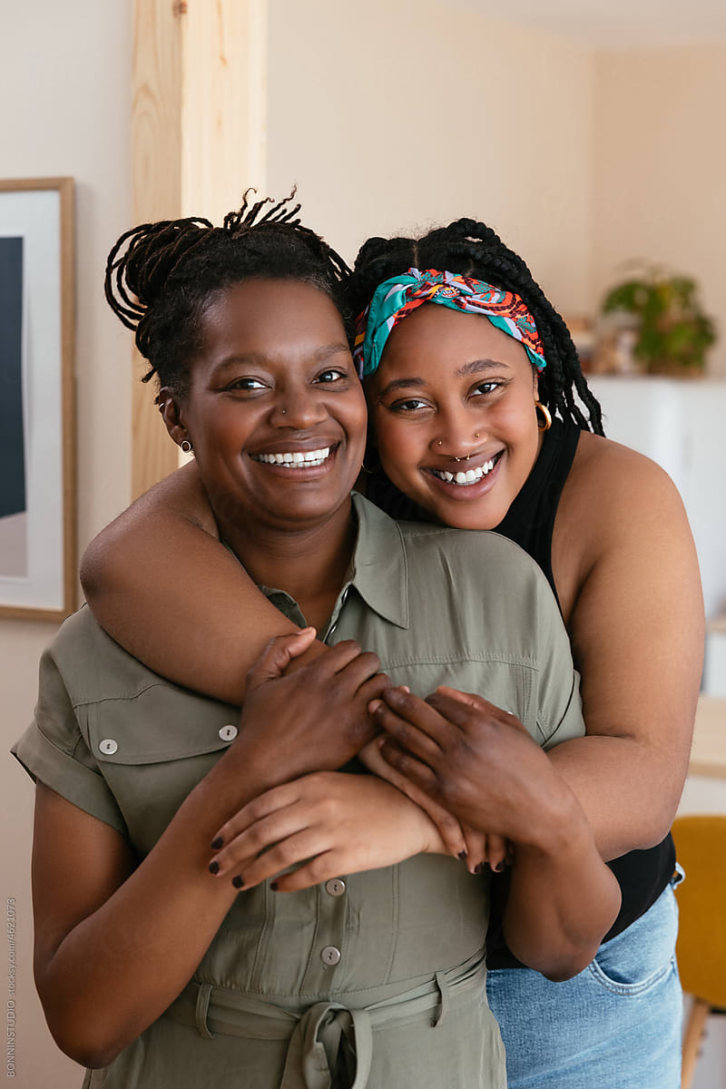 Happy black mom and daughter looking at camera