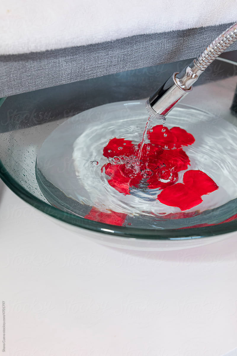 Rose petals in a container with water falling in a spa