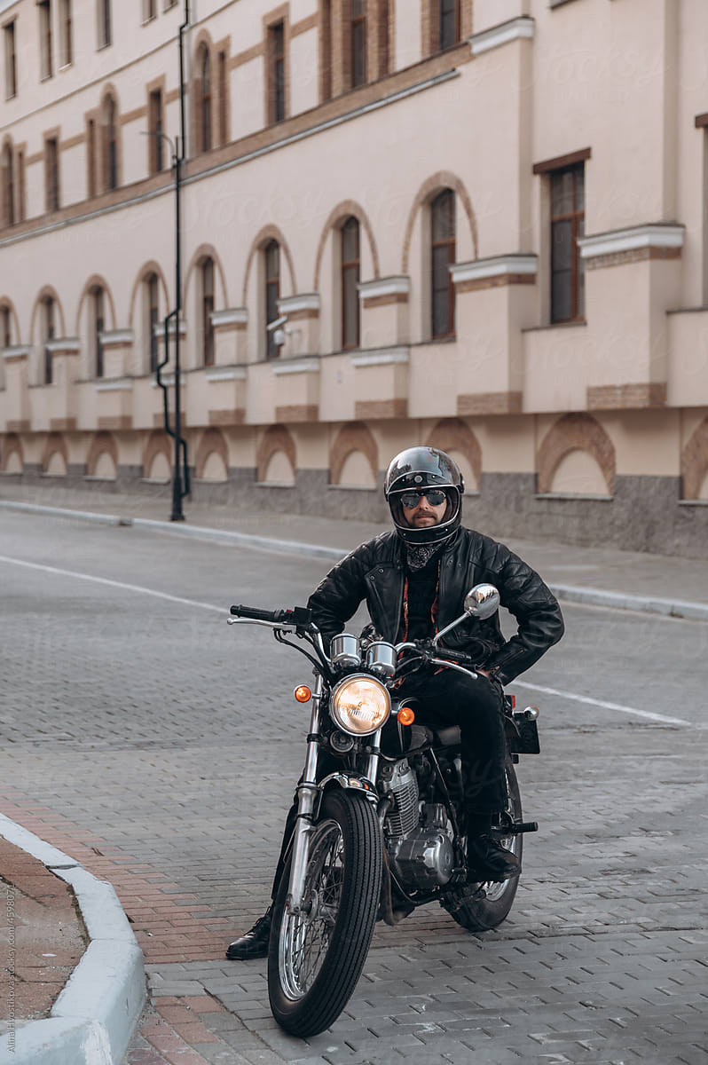 Confident biker sitting on motorcycle on city street