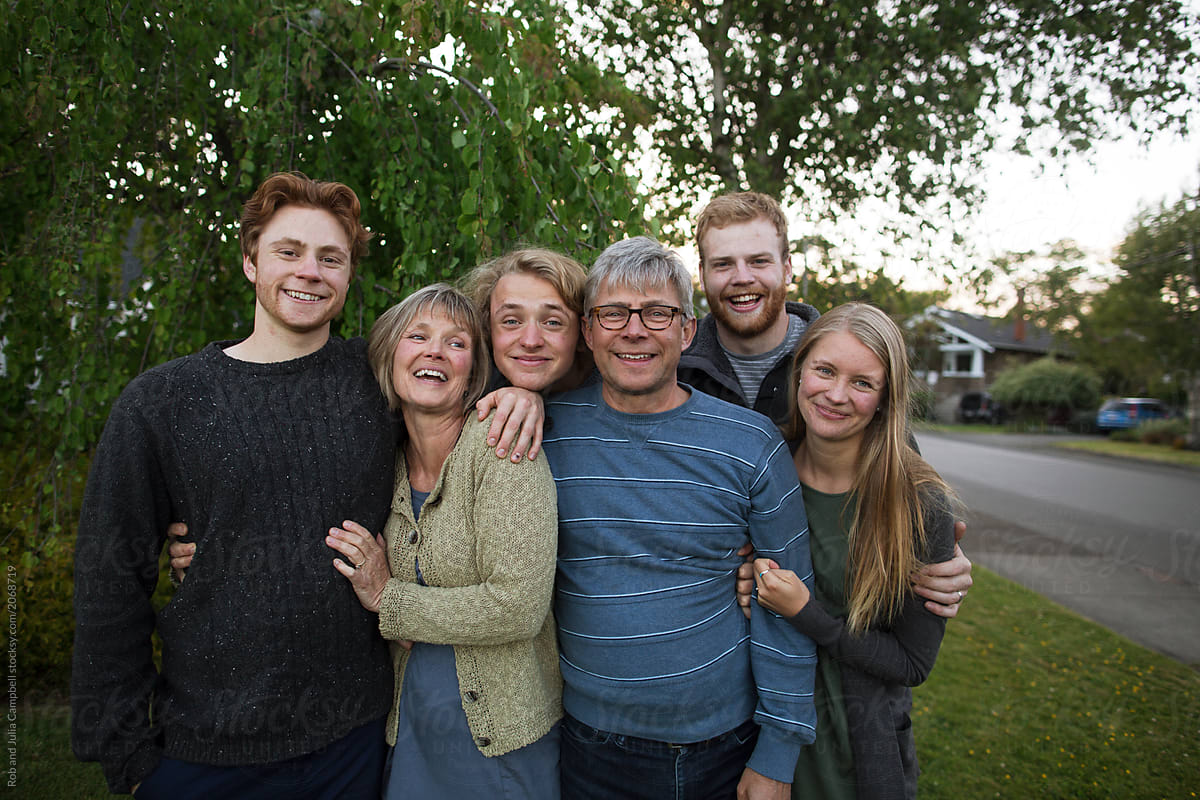 Smiling portrait of family with grown up kids outside together