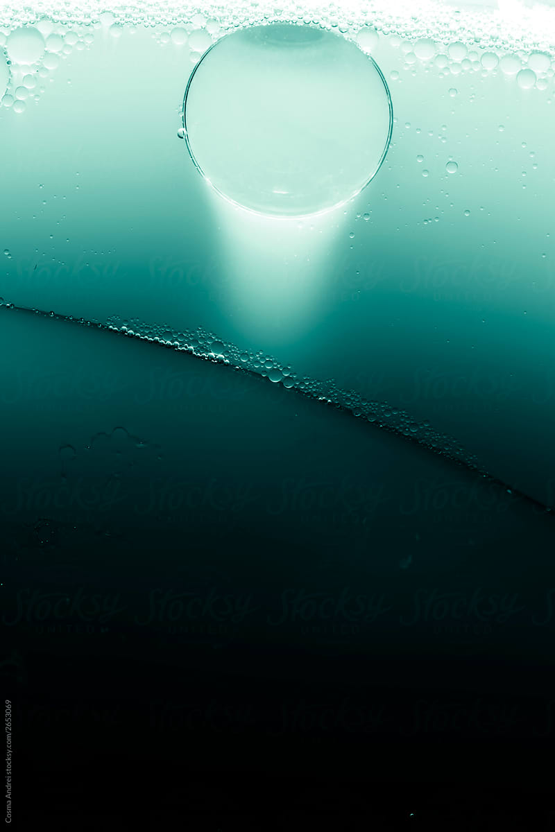 Teal background with bubble trapped under ice