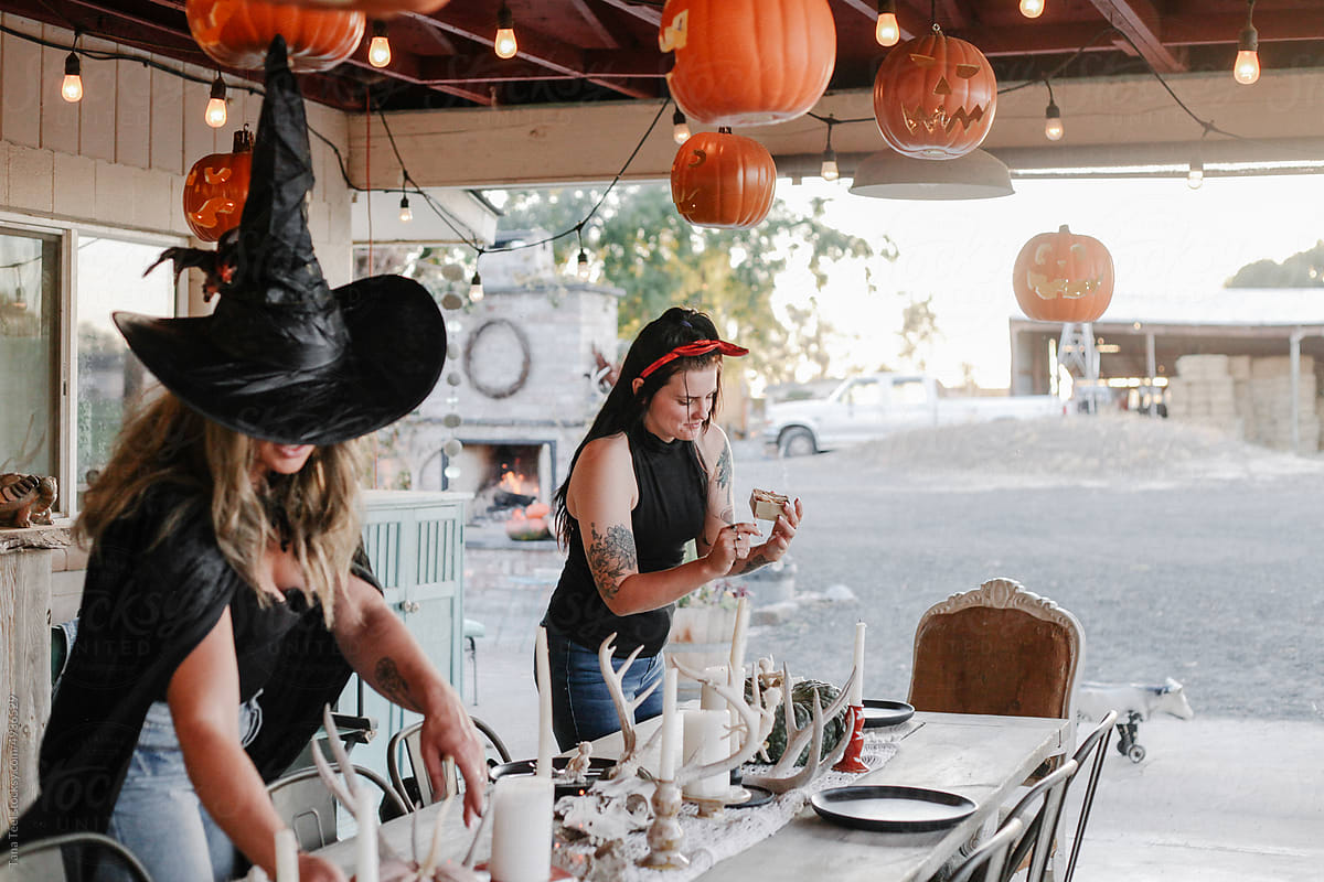 friends in costume enjoy decorating festive fall Halloween table