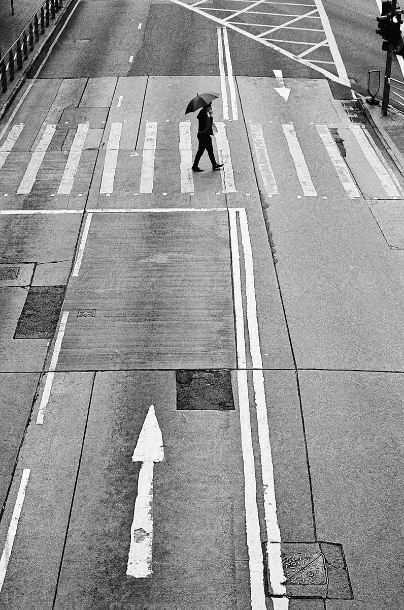 Man crossing road with umbrella