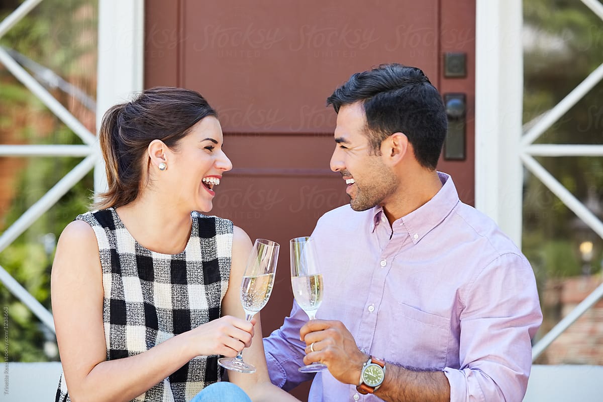 Millennial couple drinking champagne celebrating their first home purchase
