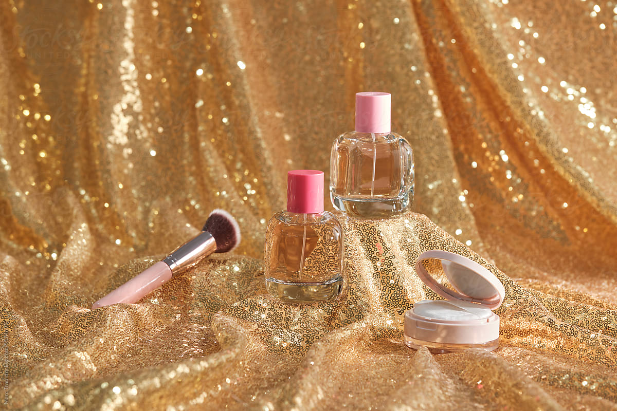 Transparent perfume bottles in golden background