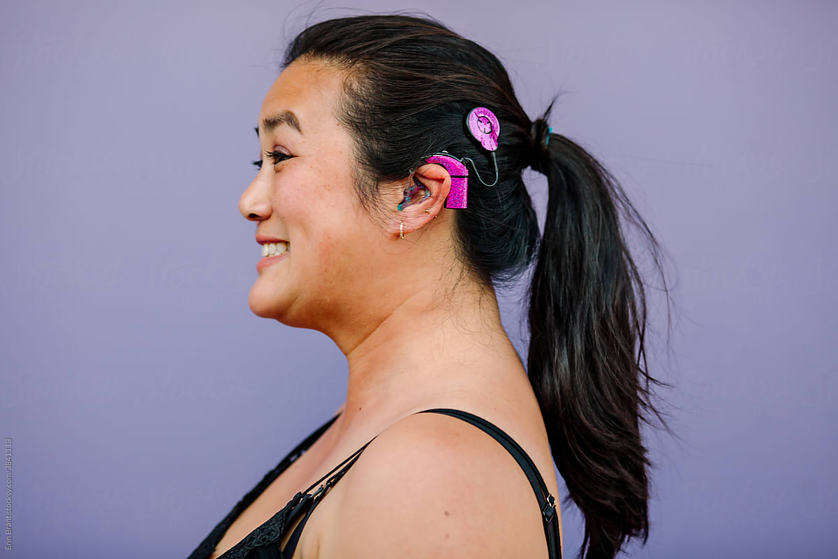 Happy Asian woman with cochlear implant