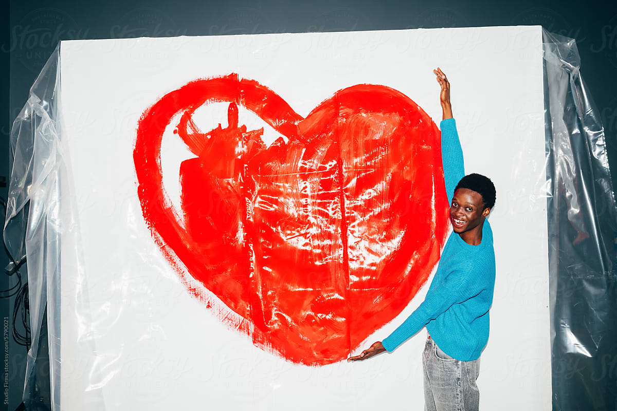 Man posing in front of big heart