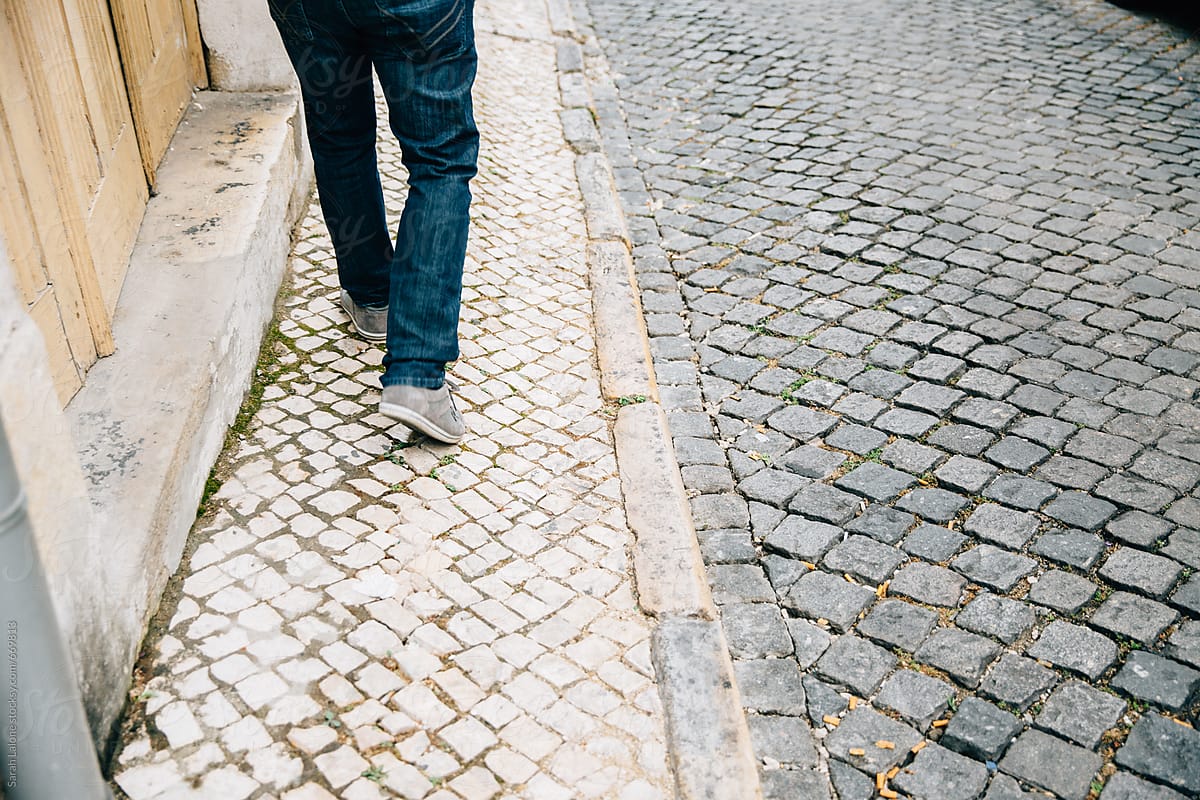 A man walking down the cobblestone streets in Lisbon