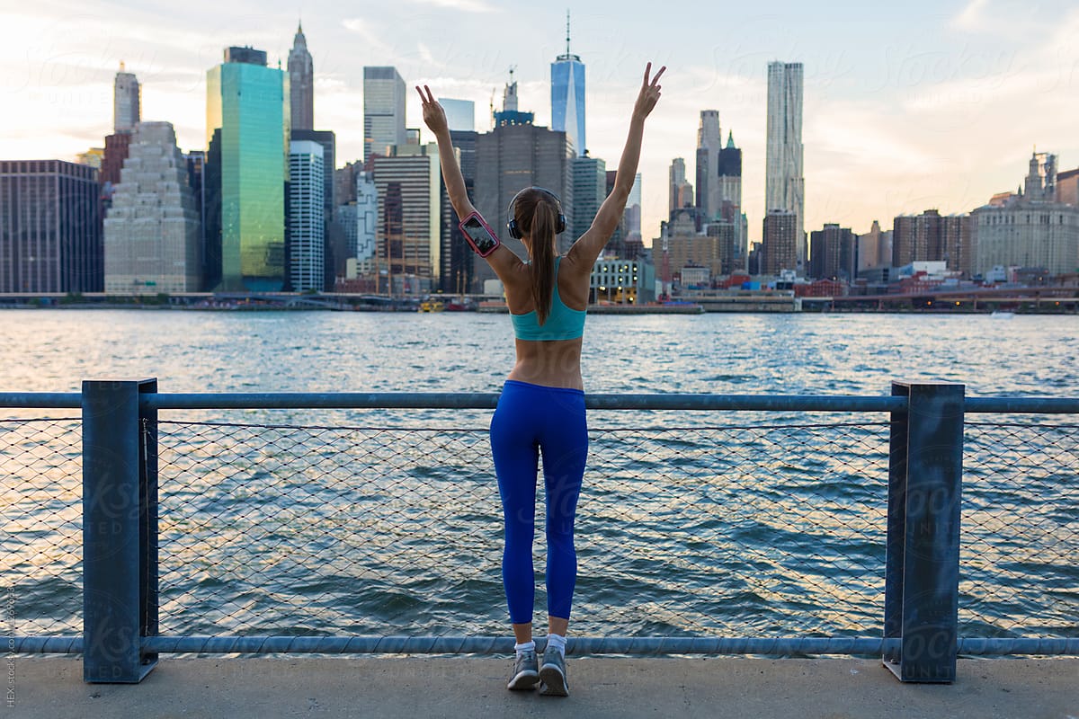 Young Beautiful Woman Doing Exercises Outdoor. Manhattan skyline View New York City