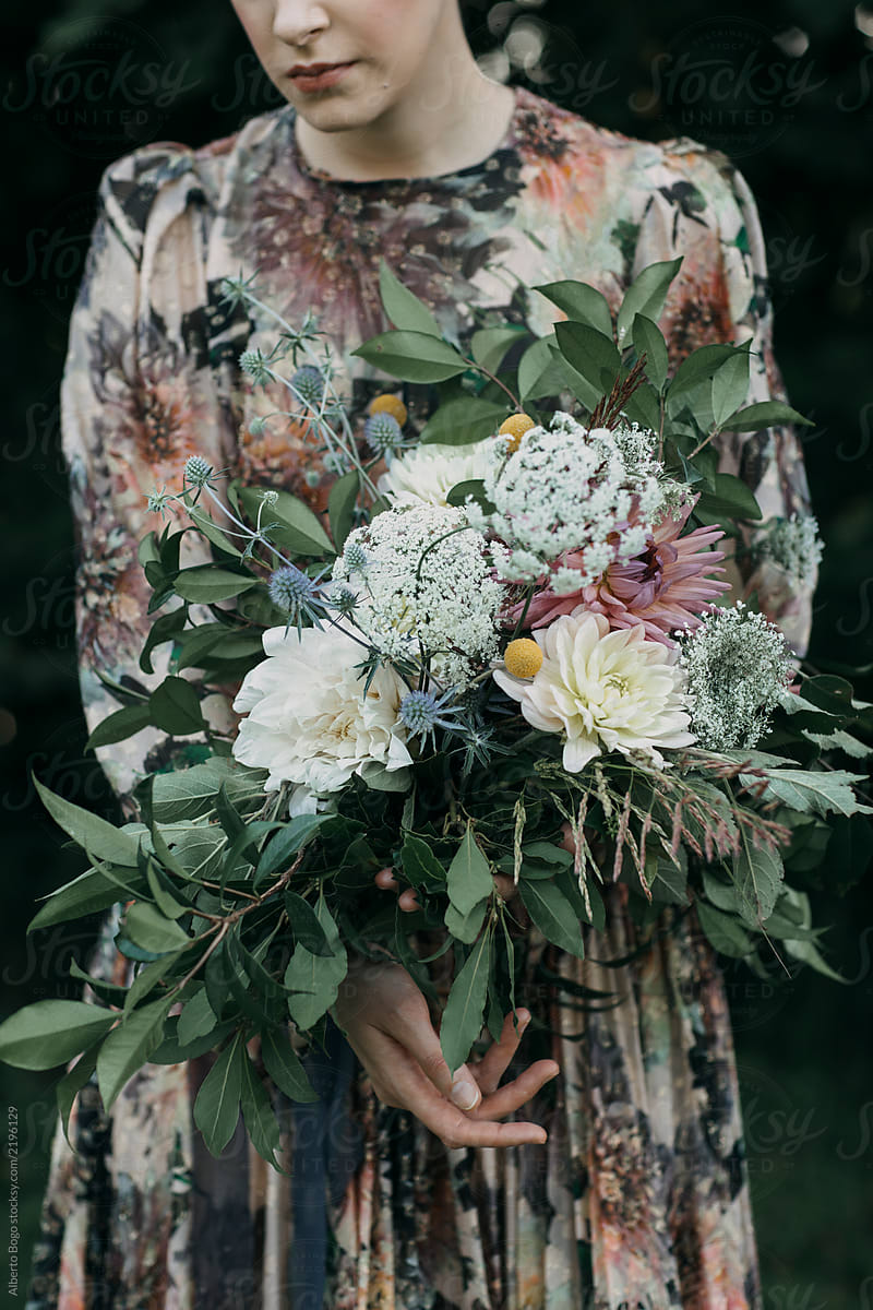 Anonymous woman in dress holding rustic bouquet