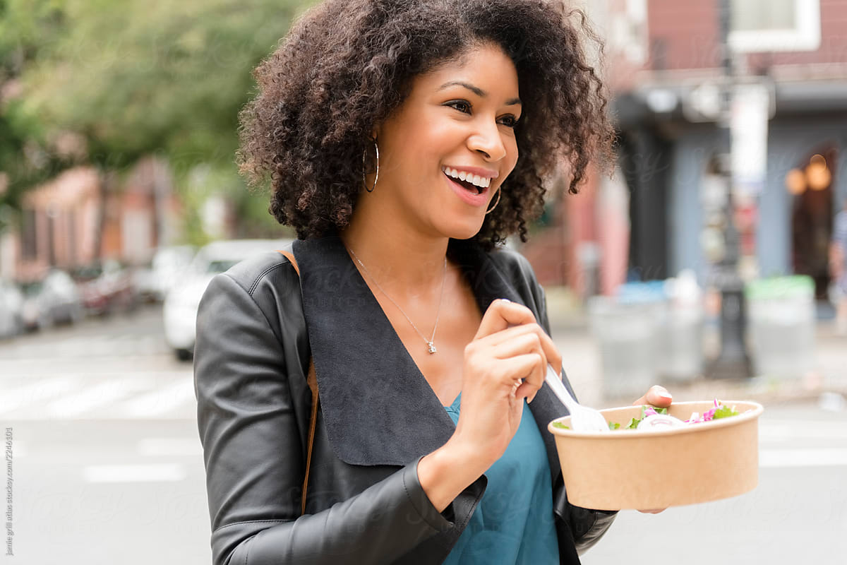 Woman eating salad on street
