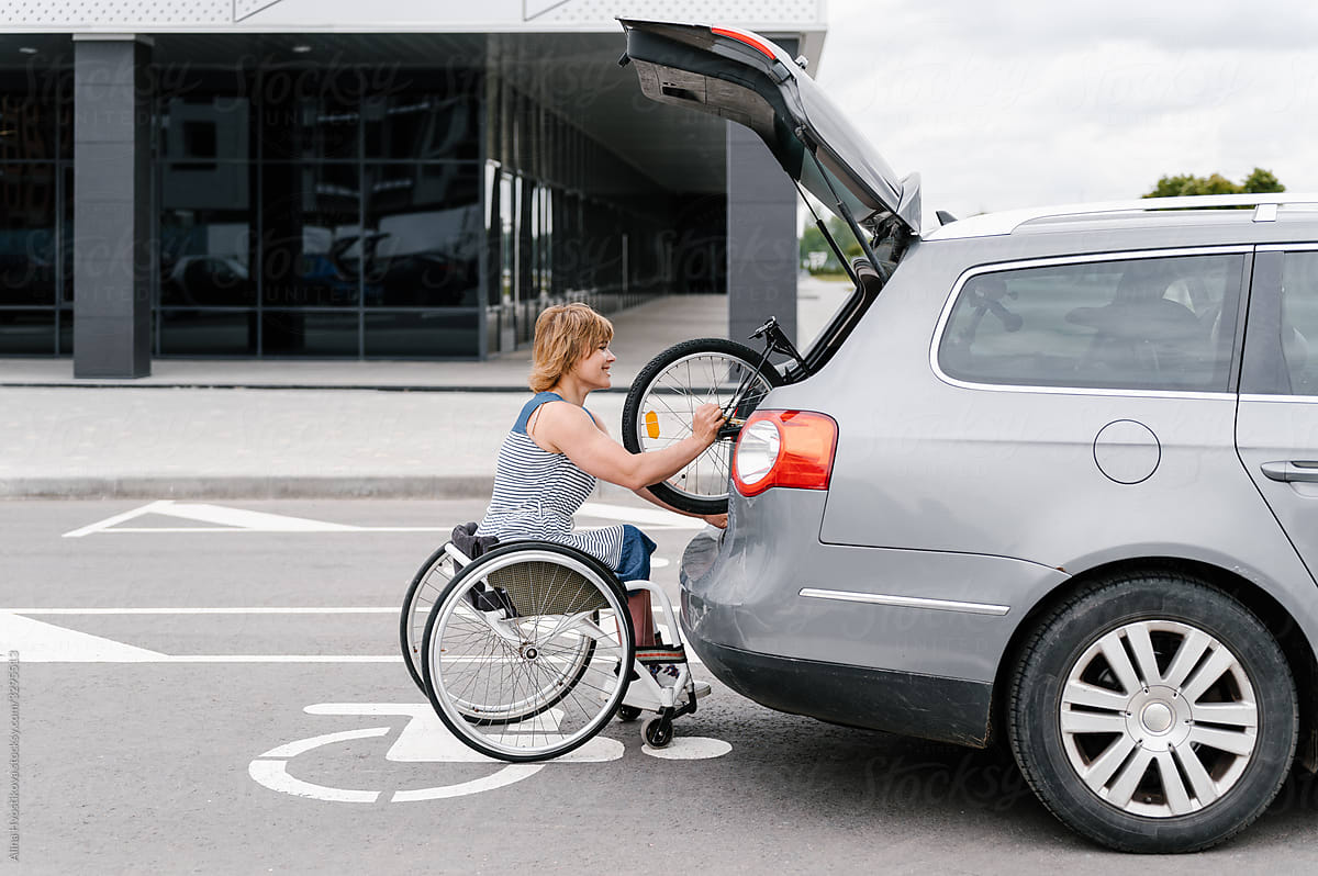 Woman with disability taking handbike from car
