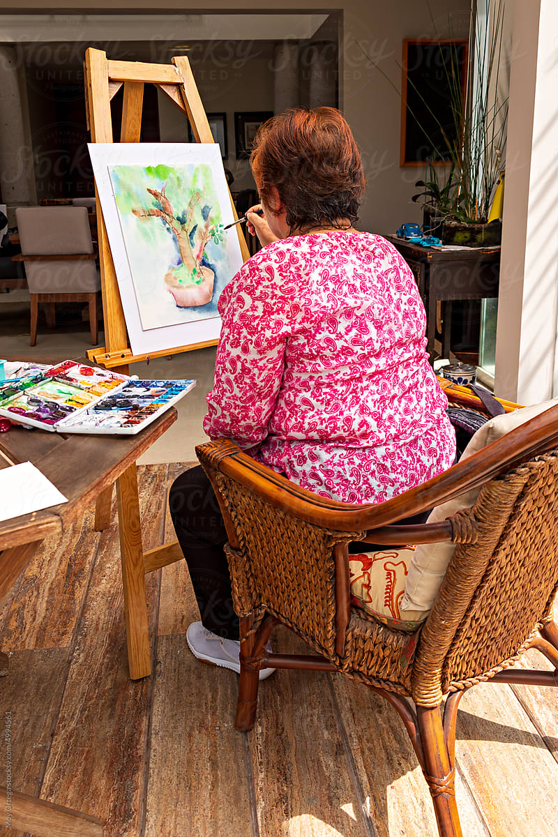 Senior lady having good time painting at home