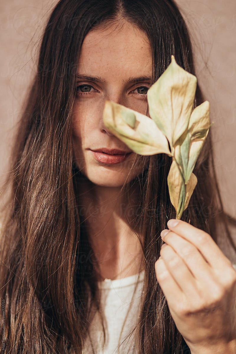 Portrait of a beautiful woman with no make up holding a leaf