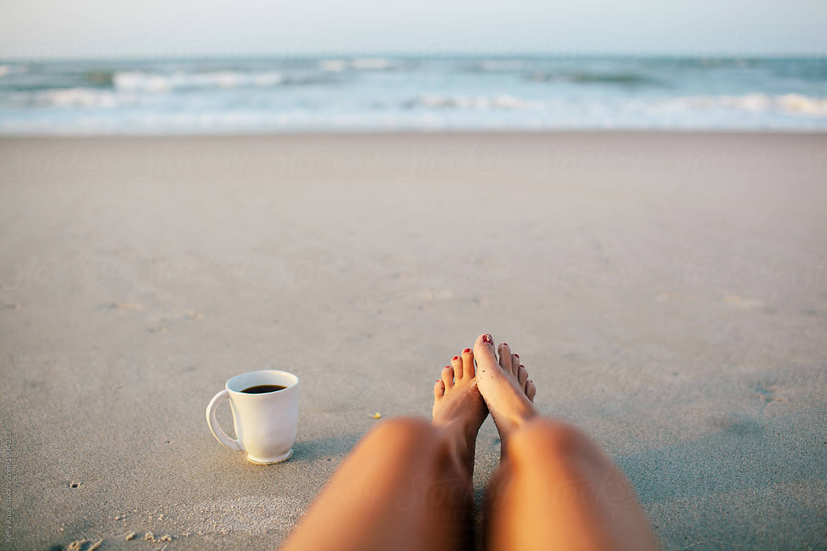 woman and a cup of coffee on the beach in the morning. woman and a cup of c...