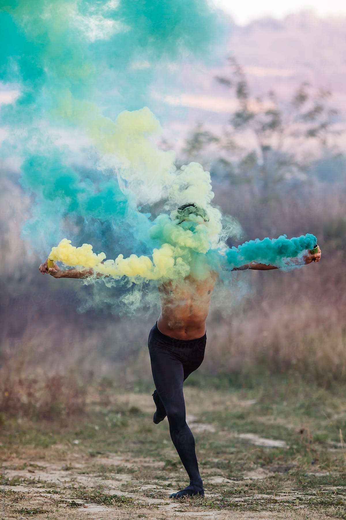 faceles , ballet dancer with two smoke bombs dance in nature