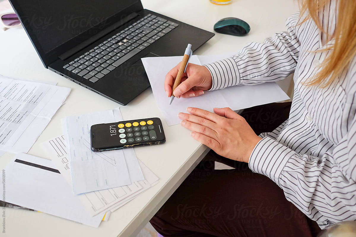 Woman paying utility bills from home calculating expenses
