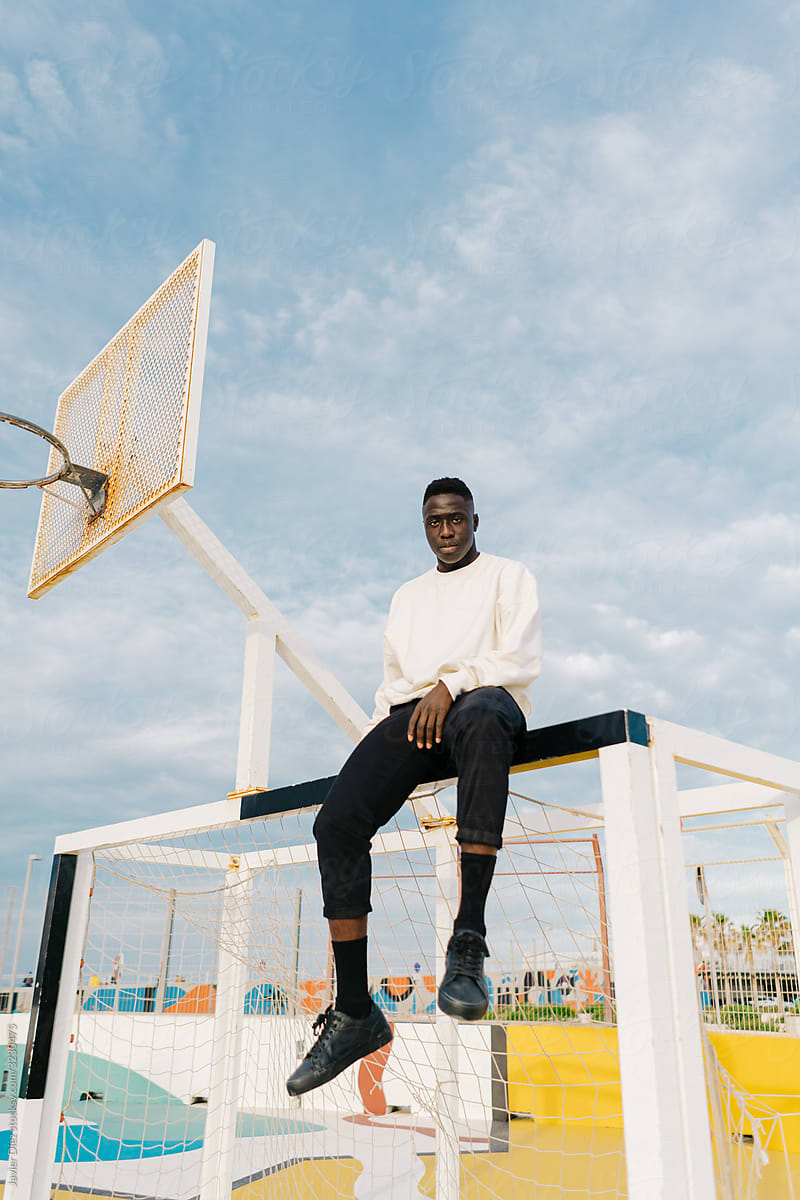 Black man sitting on basketball court