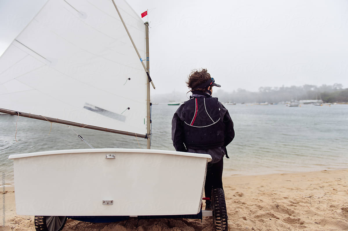 Sailor waiting to launch sail boat in bad weather