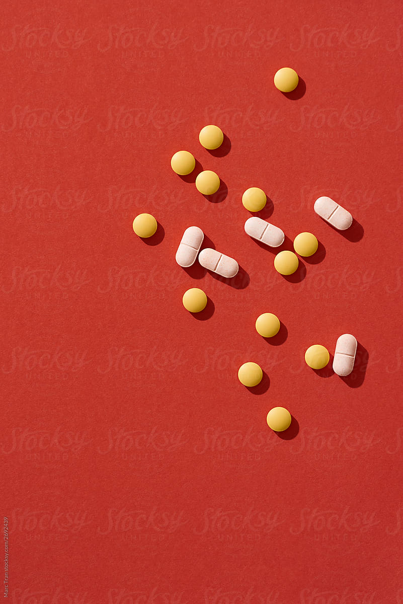 Medical pills on red background. Top view