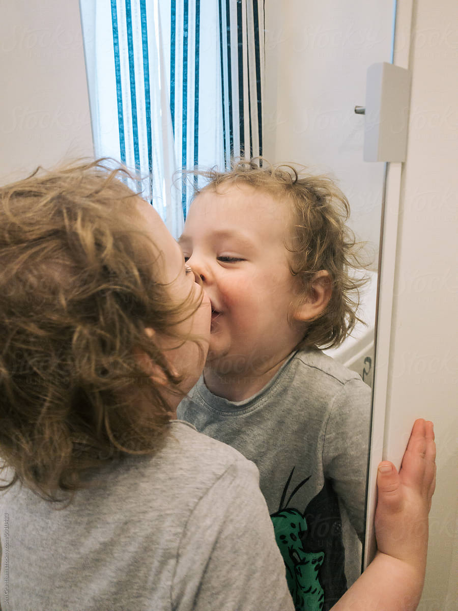 Funny child kissing mirror