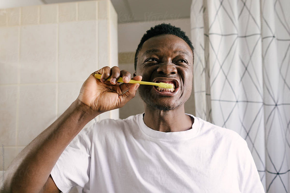 A man brushing his teeth in the bathroom at home