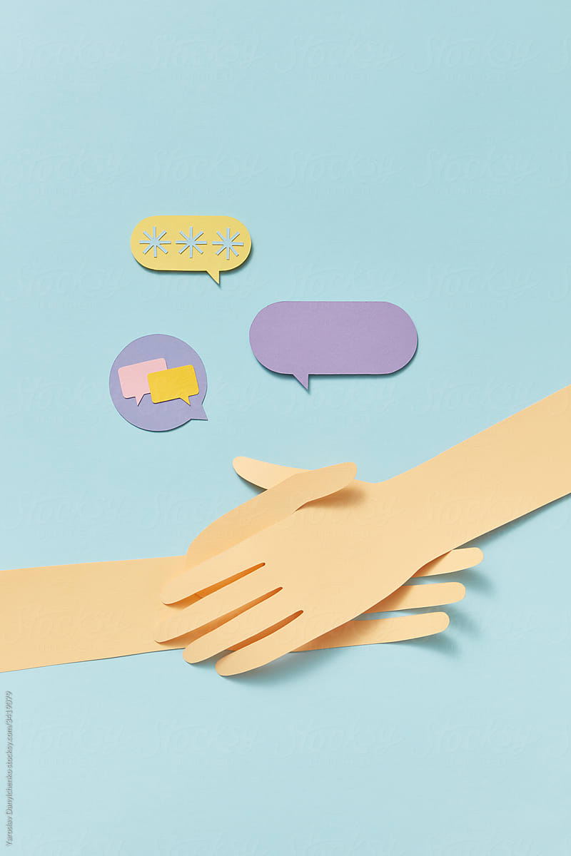 Two crossing papercraft hands with talk cloud icons.