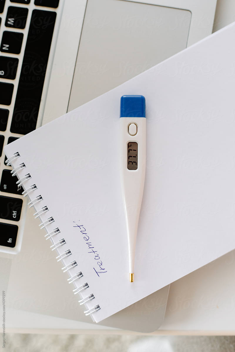 Thermometer with temperature on notebook and laptop